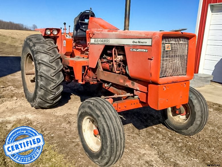 A red Stampede tractor ready for auction, sitting in a lot